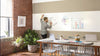 A man writing on a wall that has been painted with Benjamin Moore Notable Dry Erase paint, in a dining room.